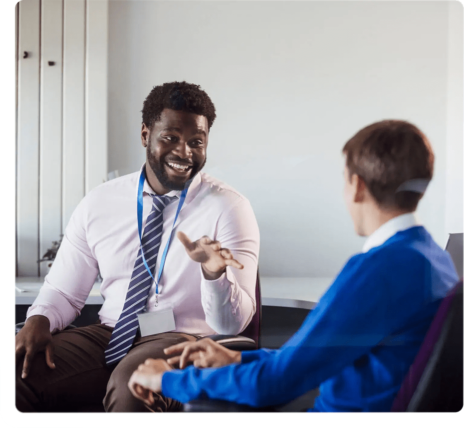 Teacher engaging with student in classroom discussion.