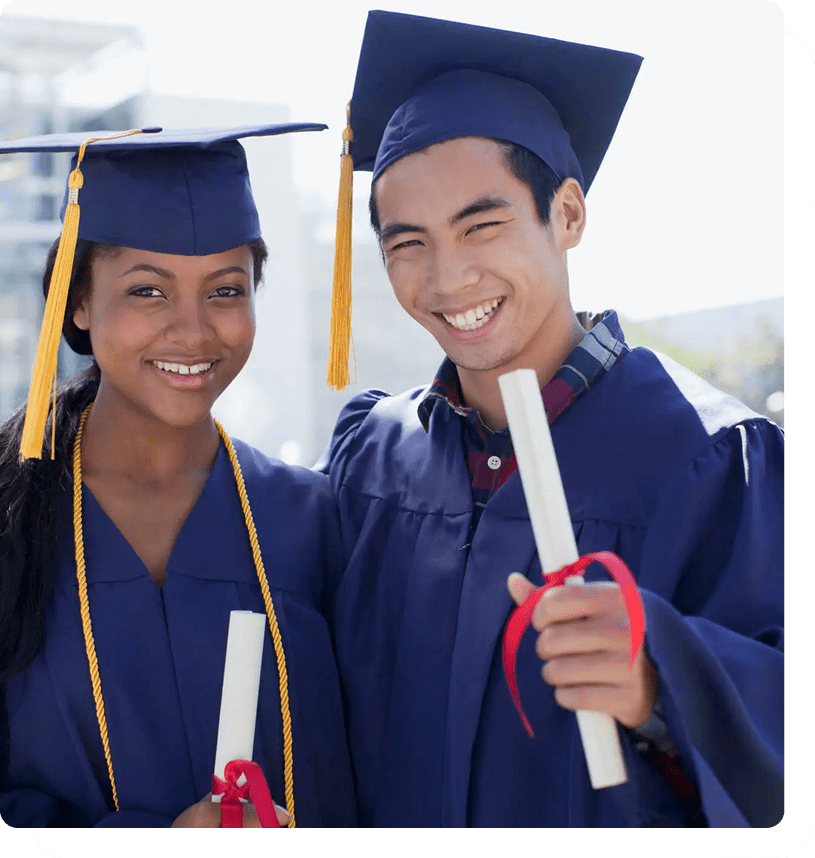 Graduates smiling in caps and gowns.