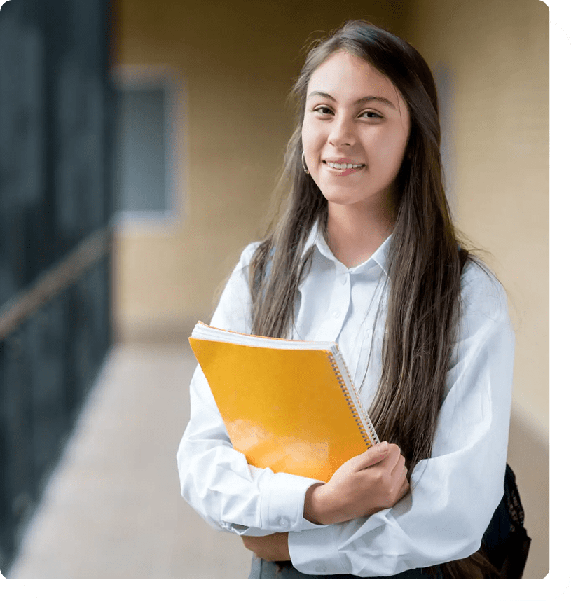 Student holding yellow notebook, smiling confidently.